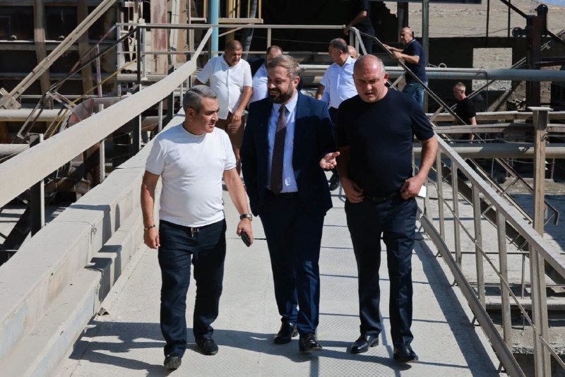Логотип ЗАО «Араратцемент» на фоне завода в городе Арарат